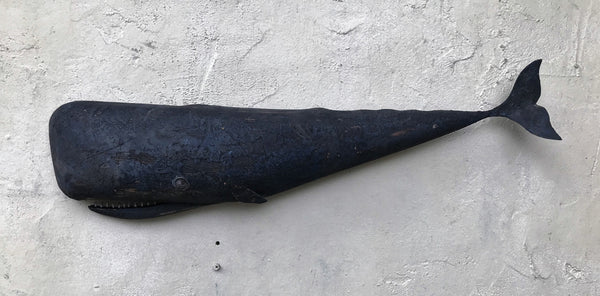 Small carved whale with metal tail.